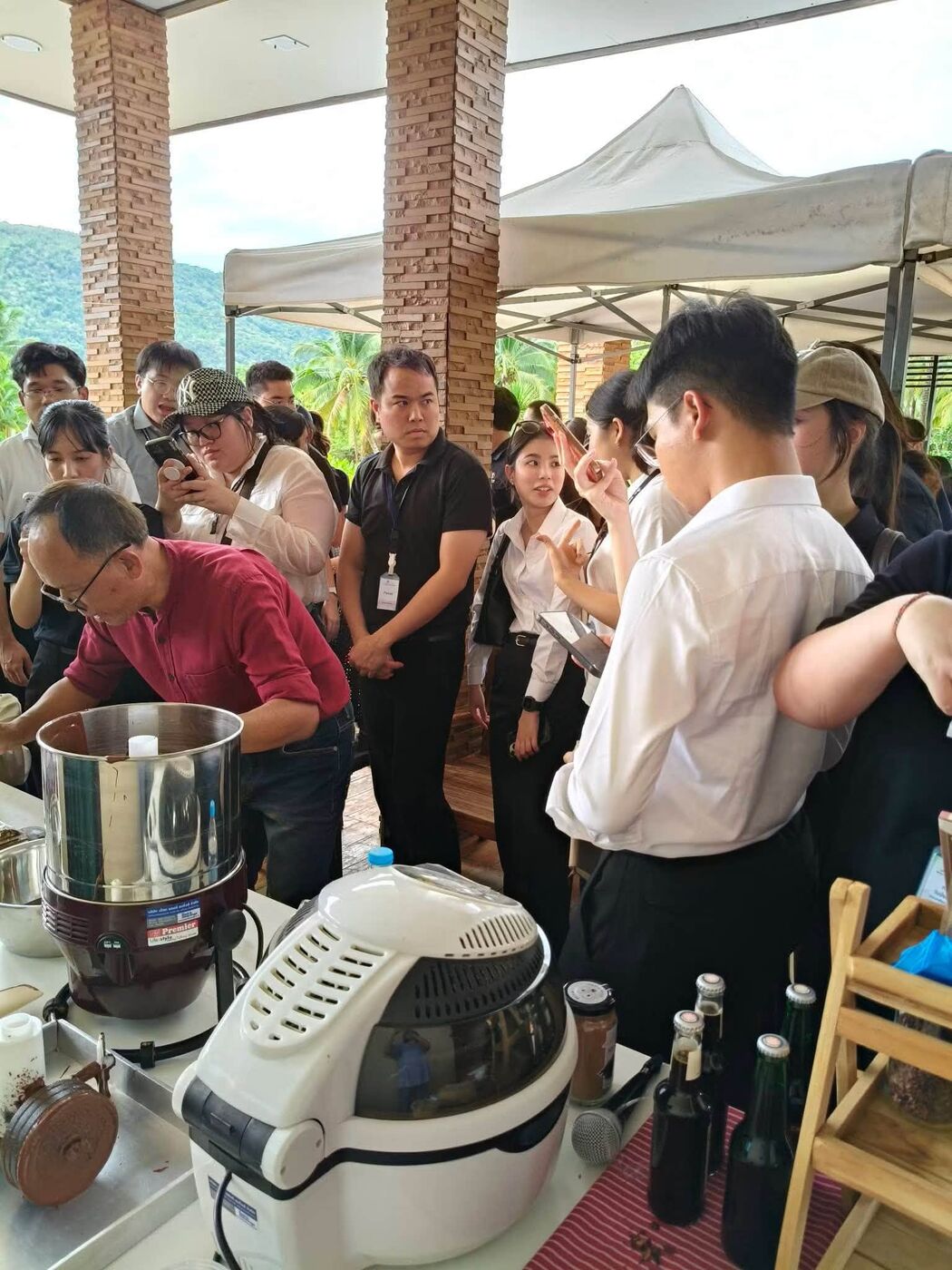 Cocoa nibs being ground in front of a student group